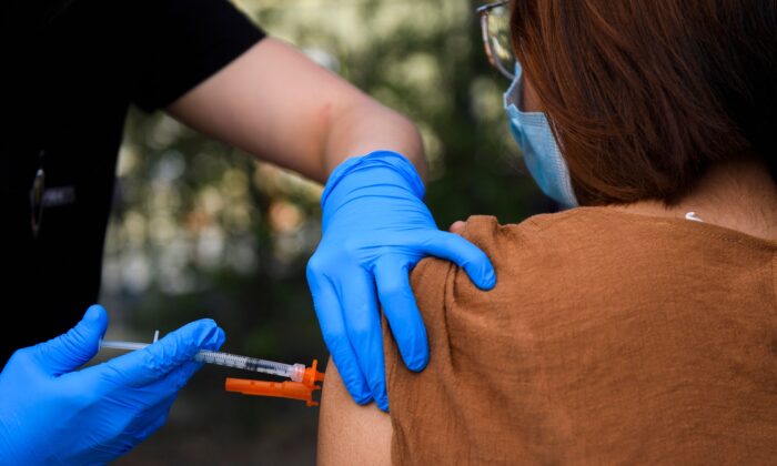 Un joven de 15 años recibe una vacuna contra COVID-19 en una clínica de vacunación móvil en Weingart East, Los Angeles YMCA en Los Ángeles, California, el 14 de mayo de 2021. (Patrick T. Fallon/AFP a través de Getty Images) Fuente: The Epoch Times en español